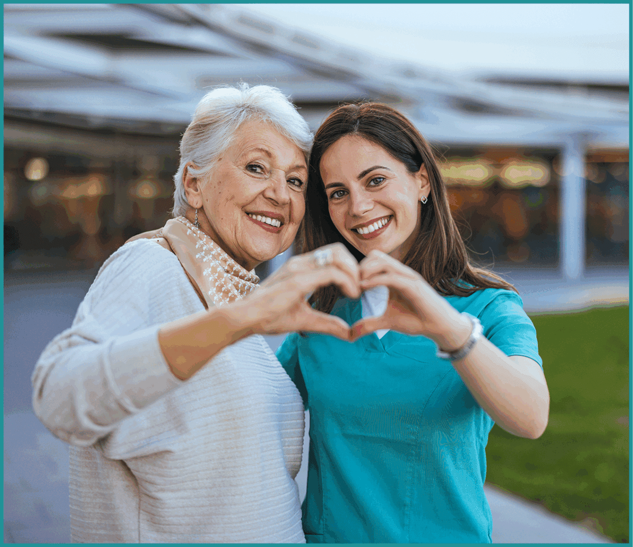 Two women making heart gesture outdoors